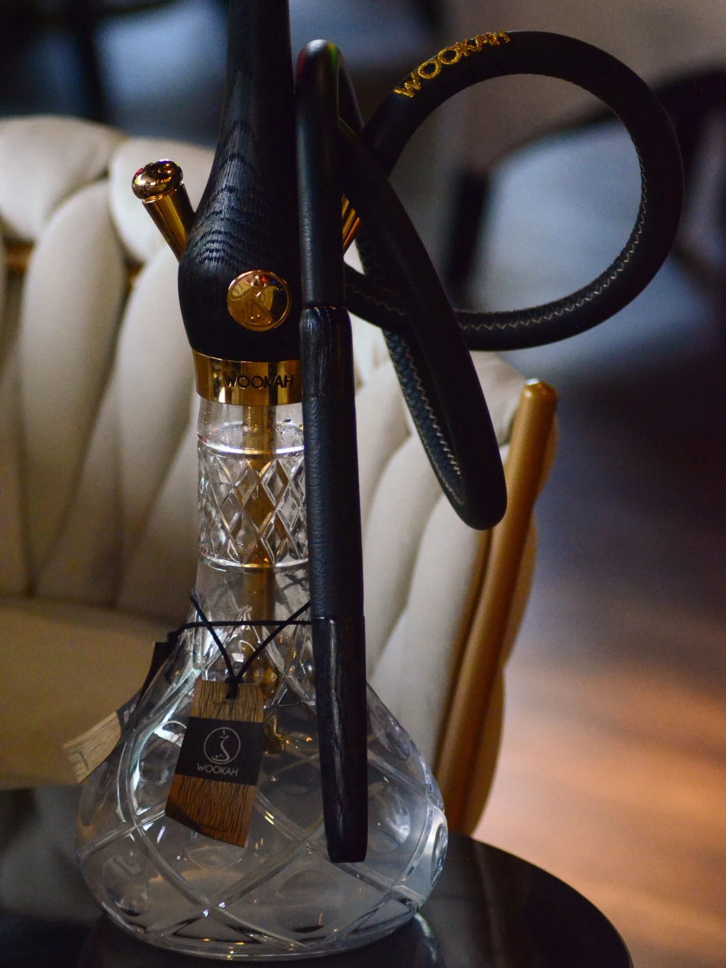 Shisha mit gläserner Bowl vor der Lounge-Sitzbank