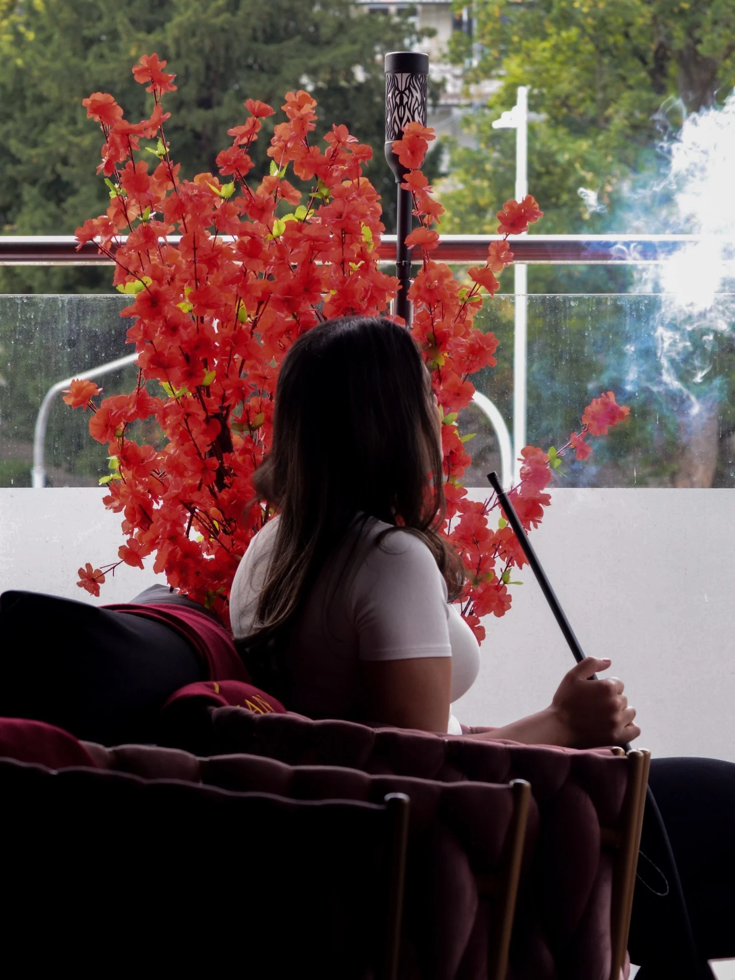 Ein Gast in der Zenzasian-Lounge neben roten Blüten